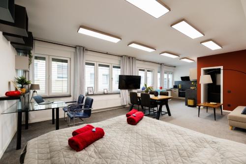 a bedroom with a large bed with two red pillows on it at Loft im Zentrum von Bad Hersfeld mit modernem Design und offenem Wohnkonzept "Badestube" in Bad Hersfeld