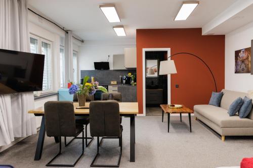 a living room with a table and a couch at Loft im Zentrum von Bad Hersfeld mit modernem Design und offenem Wohnkonzept "Badestube" in Bad Hersfeld
