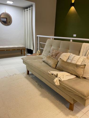 a couch with pillows on it in a living room at Casa Para Hóspedes em Peruíbe - SP in Peruíbe
