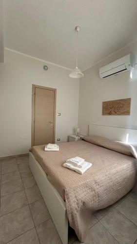 a bedroom with a bed with two towels on it at La Lanterna Apartment in Canicattì