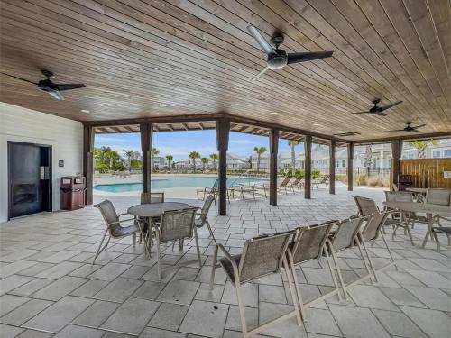 a patio with a table and chairs and a pool at Coastal Bummz in Orange Beach