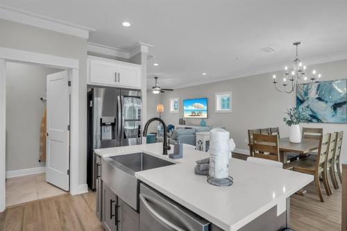 a kitchen and living room with a sink and a table at Coastal Bummz in Orange Beach