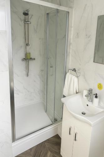 a white bathroom with a shower and a sink at City Centre Room - Walk to Station - Fast Wi-Fi in Coventry