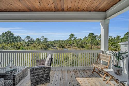a patio with chairs and a table on a deck at Coastal Bummz in Orange Beach
