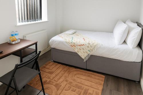 a bedroom with a bed and a desk and a chair at City Centre Room - Walk to Station - Fast Wi-Fi in Coventry