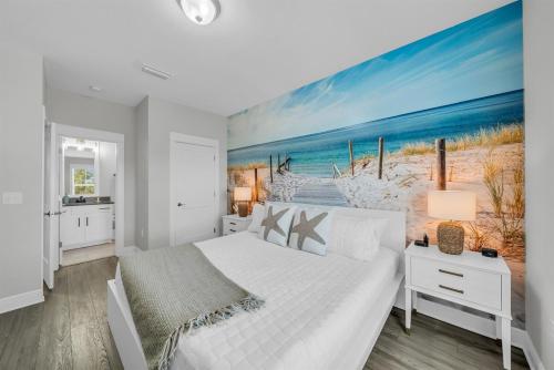 a white bedroom with a large painting of a beach at Coastal Bummz in Orange Beach
