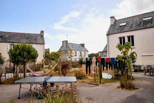 a ping pong table in a yard with houses at Vacances à l'école ! in Cléden-Cap-Sizun