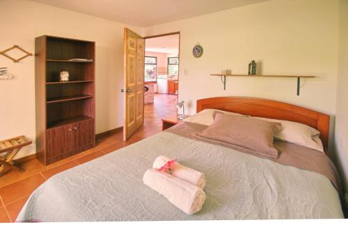 a bedroom with a bed with two towels on it at Casita Amapola in Tilarán
