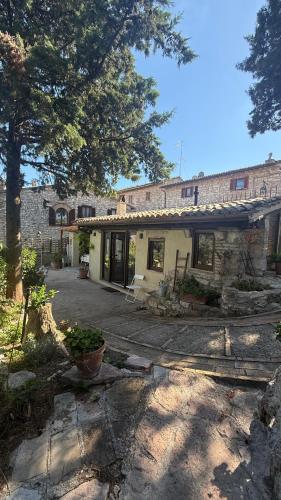 a stone house with a patio in front of it at La Sorgiva in Assisi
