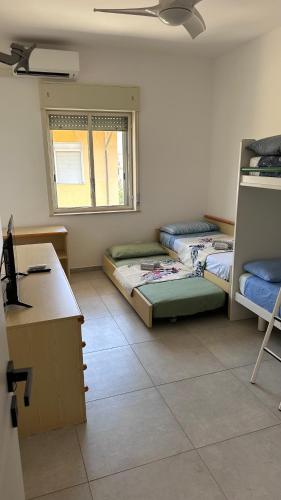 a room with two beds and a desk and a window at Casa vacanze la Casa di Erme in Torre Forte