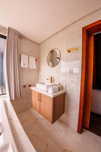 a bathroom with a sink and a tub and a mirror at Chalé com hidro e vista! in Imaruí