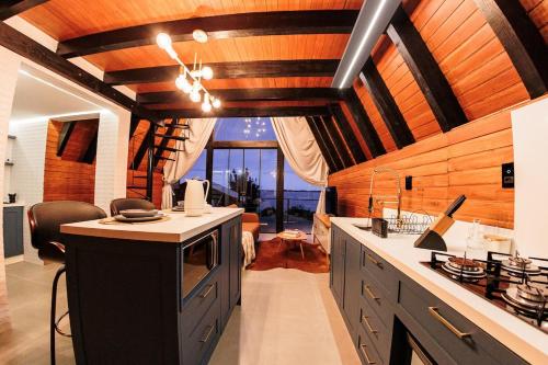 a kitchen with wooden ceilings and a counter with a sink at Chalé com hidro e vista! in Imaruí