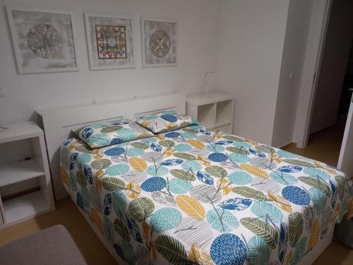a bed with a colorful comforter in a bedroom at Charming Beach Villa Porto Santo in Porto Santo