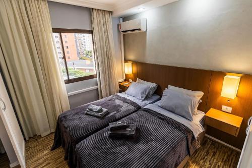 a hotel room with a bed with a suitcase on it at #TW1301 | ZER01 Suítes |Flat em Hotel Vila Olimpia in Sao Paulo