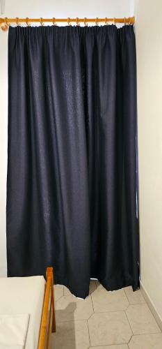 a black curtain in the corner of a room at Argiro's apartment at Agia Galini in Agia Galini