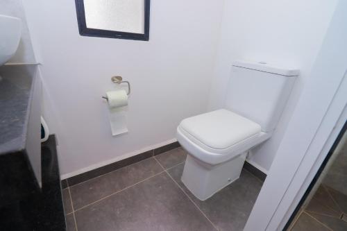 a bathroom with a toilet and a roll of toilet paper at Luxury 2-Bedroom Modern Apartment in Tatu City