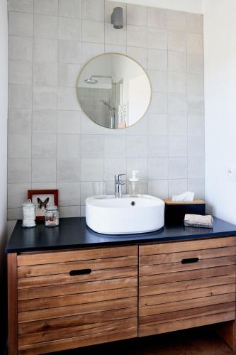 a bathroom with a sink and a mirror at Vacances à l'école ! in Cléden-Cap-Sizun