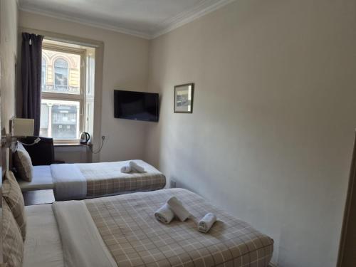 a hotel room with two beds and a flat screen tv at Glasgow House in Glasgow