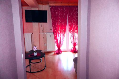 a living room with red curtains and a table and a window at Holiday Rhein 4 in Boppard