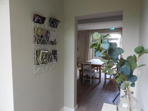 a dining room with a table and a vase with a plant at Ô lit de l'Ourthe in Hotton