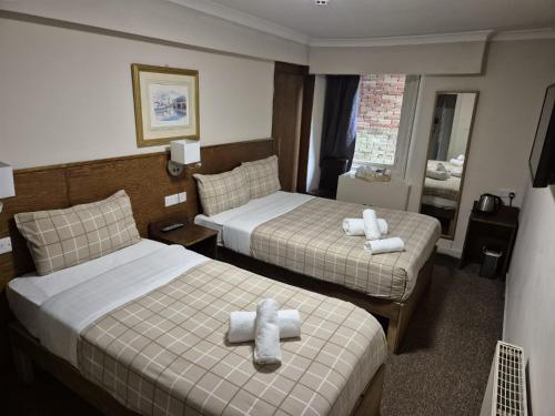 a hotel room with two beds with towels on them at Glasgow House in Glasgow