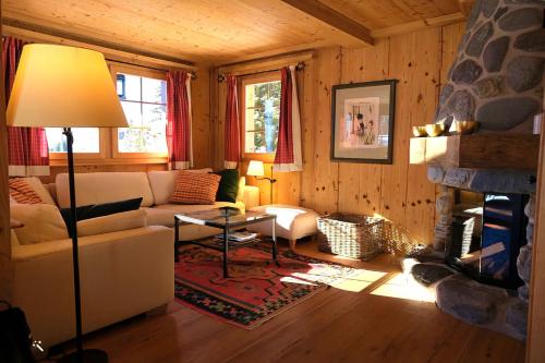 a living room with a couch and a fireplace at Chratidudel - Ski-in , Ski-out in Bettmeralp