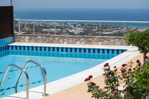 a swimming pool with a view of the ocean at The Noverian Scenic Crete 5 Star Hilltop Villa Resort & Spa in Malia