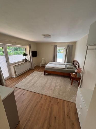 a bedroom with a bed and two windows at Terrassenwohnung im Alstertal in Hamburg
