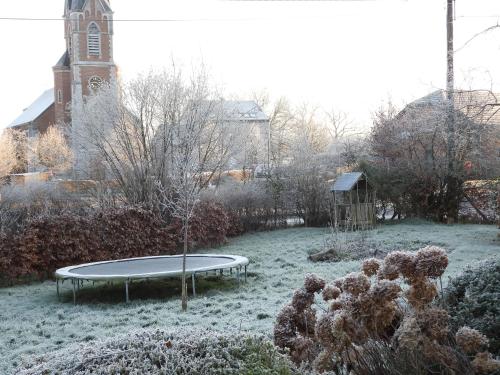 a ping pong table in the snow with a church at Ô lit de l'Ourthe in Hotton