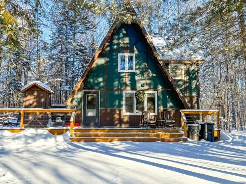 a green cabin in the snow in the woods at Rocky Pines UP in Bessemer