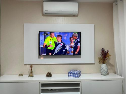 a flat screen tv sitting on a wall at Apartamento suíte com estacionamento in Porto Alegre