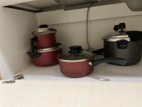 three pots and pans on a stove in a kitchen at Apartamento suíte com estacionamento in Porto Alegre