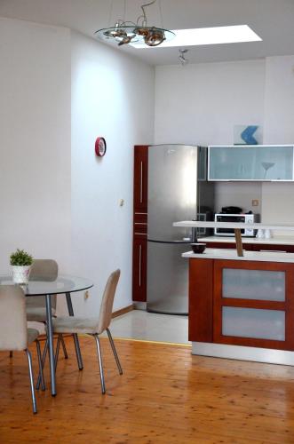 een keuken met een tafel en een roestvrijstalen koelkast bij Słoneczny Apartament w centrum Sopotu Dolnego in Sopot