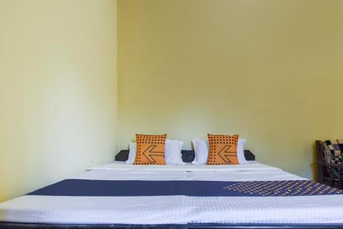 a bedroom with a bed with orange and blue pillows at SPOT ON Saini Guest House in Roorkee
