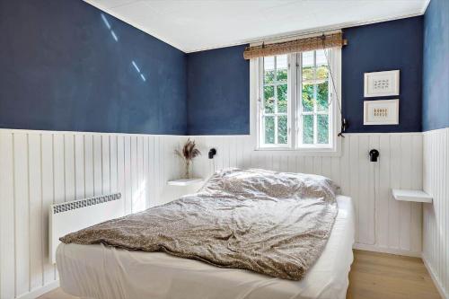 a bedroom with a bed with a blue wall at LF391-Vestervig-Gunhildsvej-1 in Vestervig