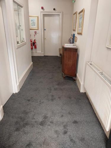 a hallway with a room with a table and a door at Glasgow House in Glasgow