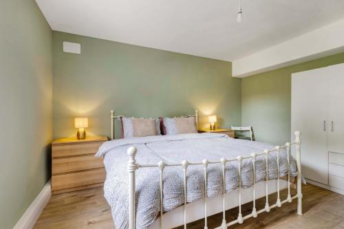a bedroom with a white bed and two lamps at Garden Apartment in Monaghan