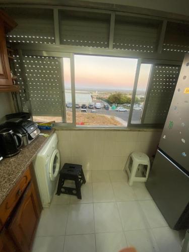 a kitchen with a view of the ocean from a window at Helder&Joana Five Star Holiday in Póvoa de Santa Iria