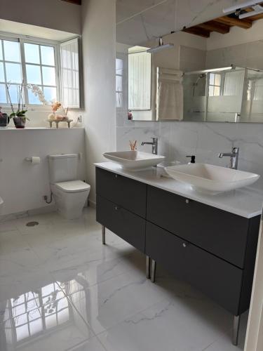 a bathroom with two sinks and a toilet at Casa con piscina in Cedeira
