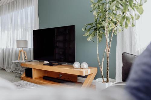 a living room with a flat screen tv on a table at Hokitika Beach Break in Hokitika