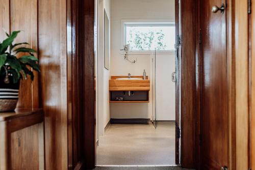 a hallway with a bathroom with a sink and a window at Hokitika Beach Break in Hokitika