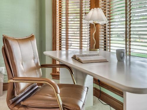 a desk with a chair and a lamp and a book at The Big Friendly - A family retreat, heated pool, hot tub, game room minutes away from DT OKC in Oklahoma City