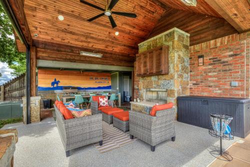 an outdoor patio with furniture and a fireplace at The Big Friendly - A family retreat, heated pool, hot tub, game room minutes away from DT OKC in Oklahoma City
