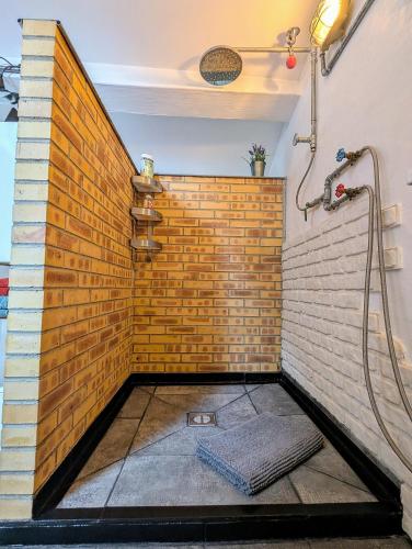 Le DoratにあるGarage Number 9 Private Urban Loft Apartment with Jacuzzi in Le Doratのレンガの壁の客室で、シャワーが備わります。