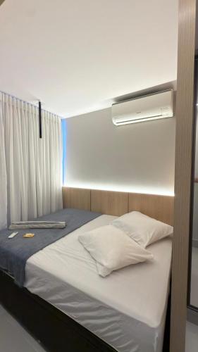 a small bed in a room with a window at Flat magnífico bairro nobre in Imperatriz