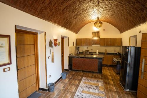 a kitchen with a refrigerator and a counter top at The Village House with Private Garden - Four Bedroom Nubian Home on Luxor West Bank in Luxor
