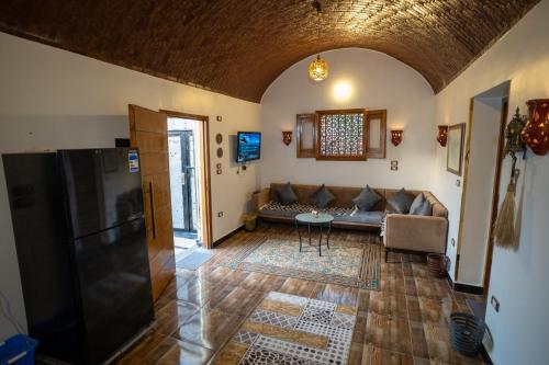 a living room with a couch and a table at The Village House with Private Garden - Four Bedroom Nubian Home on Luxor West Bank in Luxor