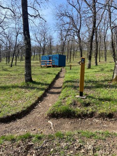 a path in a park with a bench and trees at El Roble Glamping - Cabaña Container - Pet Friendly in Lagunilla