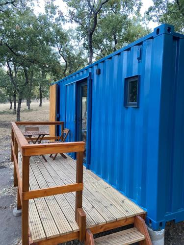 a blue tiny house with a bench on a deck at El Roble Glamping - Cabaña Container - Pet Friendly in Lagunilla