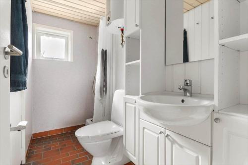 a white bathroom with a toilet and a sink at LF16021-Farso-Kjeldhoj-121 in Farsø